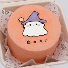 a cake in a box with an image of a ghost on it's side