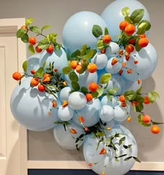 a bunch of blue balloons with oranges on them hanging from a wall in front of a door