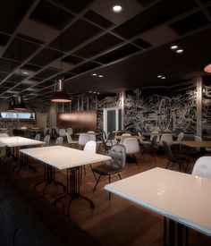 an empty restaurant with tables and chairs in front of a chalkboard mural on the wall