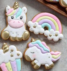 decorated cookies with unicorns and rainbows are on the table next to each other