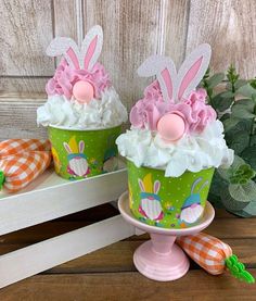 two cupcakes decorated with bunny ears and white frosting