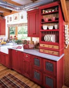 a kitchen with red cabinets and white counter tops