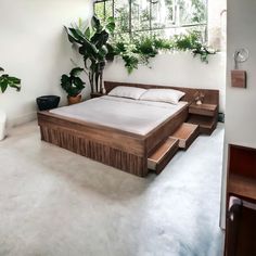 a large bed sitting inside of a bedroom next to a plant