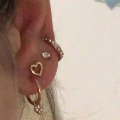 a close up of a person's ear with two rings attached to it and a heart on the side