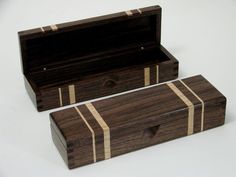 two wooden boxes sitting next to each other on a white surface with one open and the other closed