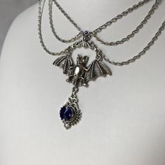 This gothic vampire inspired necklace is made with an antiqued silver plated bat. filigrees and findings, accented with sparkling glass crystals in DARK SAPPHIRE BLUE. Decorated portion is 6" wide and centerpiece is 2 7/8" tall in the center.Necklace is adjustable 15-18" with a lobster clasp and chain extender in the back. If you would like a different length or stone color, please send us a message. Silver Vampire Style Necklace, Gothic Nickel-free Necklace For Halloween, Gothic Nickel-free Necklaces For Halloween, Silver Vampire Style Choker Necklace, Nickel-free Gothic Necklaces For Party, Halloween Gothic Pendant Jewelry, Silver Vampire Style Metal Jewelry, Silver Vampire Costume Jewelry, Silver Vampire Style Costume Jewelry