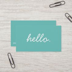 a blue business card with the word hello on it next to some office supplies and paper clips