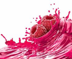 raspberries are splashing into the water on a white background with pink colors