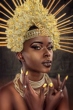 a woman with gold nails and a headdress