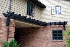 an outside view of a brick building with a black pergolan on the roof