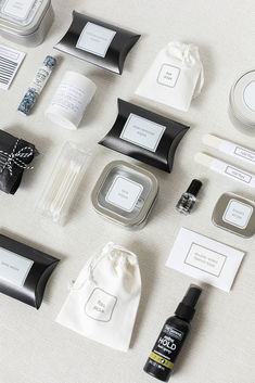 an assortment of personal care items laid out on a white tablecloth with black and silver accents