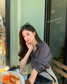 a woman sitting at a table with food in front of her