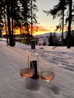 two glasses of wine sitting in the snow