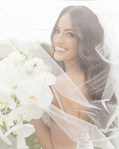 a beautiful woman holding a bouquet of white flowers