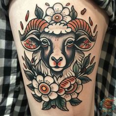 a ram with flowers and leaves on it's thigh is seen in this tattoo design