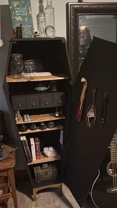 an open guitar case sitting on top of a floor next to a shelf filled with jewelry