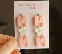 a pair of pink and white earrings on a card