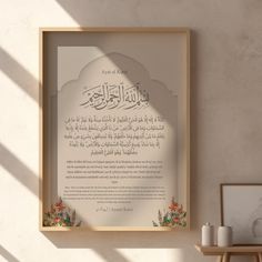 an arabic calligraphy displayed in a wooden frame on a wall next to a vase with flowers