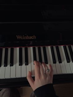 a person is playing the piano with their hand on it's keys, while sitting down