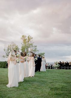 a group of people standing on top of a lush green field next to each other