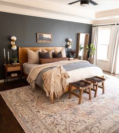 a bedroom with a large bed and two stools