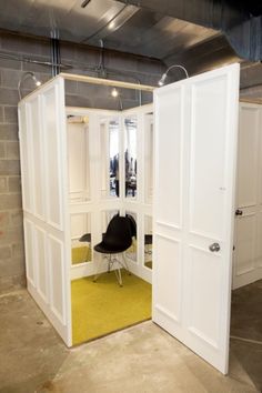 an open door leading into a room with a yellow rug on the floor and white walls