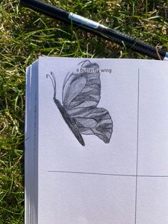 a book with a drawing of a butterfly on it and a pencil laying next to it