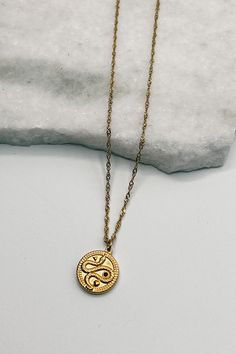 Unleash your inner strength with the Samara Gold Snake Medallion Necklace. This captivating piece features a sleek gold chain paired with a circular gold medallion, intricately engraved with a striking snake motif. Symbolizing transformation and renewal, the snake design adds a touch of mystique and elegance. Perfect for making a bold statement, the Samara necklace is a must-have addition to any jewelry collection. Snake Motif, Gold Lion, Lion Shirt, Faux Leather Purse, Tie Shirts, Snake Pendant, Gold Medallion, Studded Necklace, Medallion Necklace