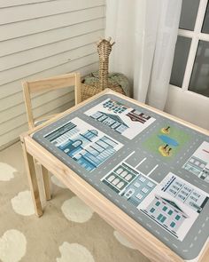 a child's table and chair in front of a house with pictures on it