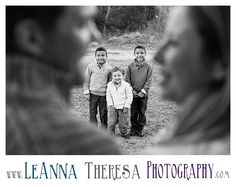 three children are standing together in the grass