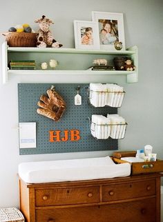 a baby changing table with some pictures on the wall above it and an image of a baseball glove