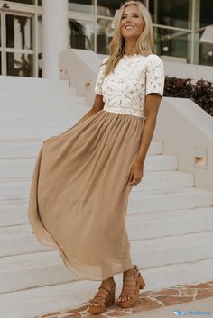 a woman standing on the steps wearing a dress and sandals with her hands in her pockets