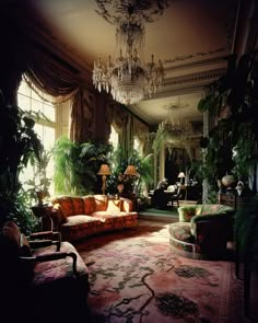 a living room filled with furniture and lots of greenery