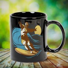 a black coffee mug with an image of a surfer riding a wave on the ocean