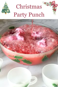 a bowl filled with pink liquid next to cups and saucers