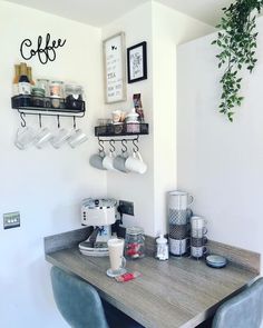 a table with some cups on top of it next to two shelves filled with coffee mugs