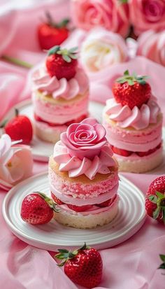 strawberry shortcakes with pink frosting and strawberries on the table next to them