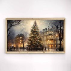 a christmas tree is lit up in the middle of a room with a painting hanging on the wall