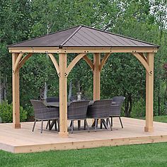 a wooden gazebo sitting on top of a lush green field