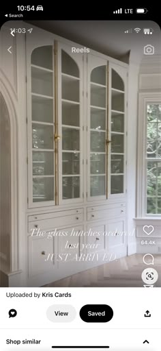 a white china cabinet with glass doors and gold handles