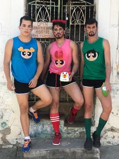 three men in matching shirts and shorts standing next to each other with their faces painted on them