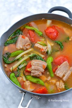 a pan filled with meat and vegetables on top of a table