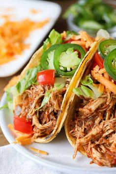 two shredded pork tacos on a white plate