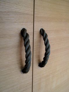 a close up of two handles on a wooden door with rope attached to the handle