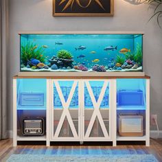 a fish tank is sitting on top of a cabinet in front of a painting and rug