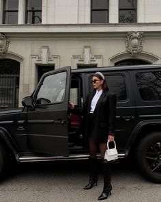 a woman standing in front of a black jeep