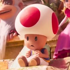 an animated mushroom is sitting on the ground next to two other cartoon characters, one in pink