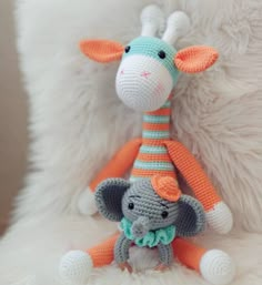 a crocheted giraffe with an orange and white striped hat