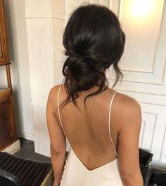 the back of a woman's dress as she sits in front of a piano