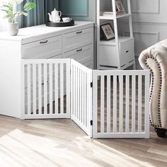 a baby crib in the corner of a room next to a chair and desk